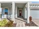 Front porch with white rocking chairs and a red front door at 8725 Sundance Loop, Sarasota, FL 34238