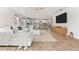 Open concept living room with white sectional and views of kitchen and backyard at 8725 Sundance Loop, Sarasota, FL 34238