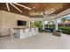 Relaxing outdoor kitchen area with bar seating and a flat screen TV at 8725 Sundance Loop, Sarasota, FL 34238