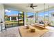Relaxing screened porch with a swing bed, ceiling fan, and view of backyard at 8725 Sundance Loop, Sarasota, FL 34238