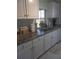 Modern kitchen with white cabinets, granite counters, and stainless steel appliances at 1002 Oakleaf Blvd, Bradenton, FL 34208