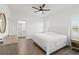 Main bedroom with a king-size bed, ensuite bathroom, and wood-look floors at 10435 Ladybug Cv, Parrish, FL 34219
