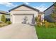 Single-story home with attached garage and landscaped front yard at 10435 Ladybug Cv, Parrish, FL 34219