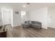 Open living area with gray sectional and wood floors at 10435 Ladybug Cv, Parrish, FL 34219