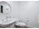 Modern bathroom with white sink, toilet, and round mirror at 1211 Gulf Of Mexico Dr # 301, Longboat Key, FL 34228