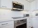 Modern kitchen with stainless steel appliances and white cabinetry at 1211 Gulf Of Mexico Dr # 301, Longboat Key, FL 34228