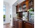 Elegant wet bar with granite countertops and glass-front cabinetry at 1211 Gulf Of Mexico Dr # 301, Longboat Key, FL 34228