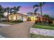 Two-story house with a paver driveway and palm trees at 16003 Kendleshire Ter, Lakewood Ranch, FL 34202