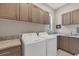 Convenient laundry room with washer, dryer, and ample cabinet space at 16003 Kendleshire Ter, Lakewood Ranch, FL 34202
