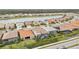 Aerial view of houses, lake, and surrounding landscape at 20296 Bandera Pl, Venice, FL 34293