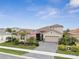 Two-story house with tan walls, tile roof, and landscaped yard at 20296 Bandera Pl, Venice, FL 34293