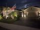 Two-story house with a landscaped yard, a flag, and a paved driveway at night at 20296 Bandera Pl, Venice, FL 34293