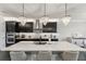 Spacious kitchen with island, stainless steel appliances, and dark cabinetry at 20296 Bandera Pl, Venice, FL 34293