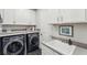 Bright laundry room, featuring washer, dryer, and utility sink at 20296 Bandera Pl, Venice, FL 34293