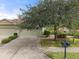 Two-car garage with driveway and mature tree at 209 Fontanelle Cir, Venice, FL 34292