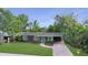 Charming ranch home with landscaped yard, brick driveway, and teal front door at 2264 Floyd St, Sarasota, FL 34239