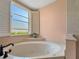 Relaxing bathroom with corner soaking tub and window at 25072 Palisade Rd, Punta Gorda, FL 33983