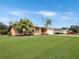 A charming house with palm trees and a lush green lawn at 25072 Palisade Rd, Punta Gorda, FL 33983