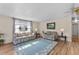 Living room with light wood floors, blue rug, and comfy sofas at 312 Tropic Dr, Osprey, FL 34229