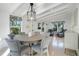 Round dining table with grey chairs, surrounded by windows overlooking the backyard at 320 29Th Nw St, Bradenton, FL 34205
