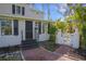 Front entrance with brick walkway, black door, and white fence at 320 29Th Nw St, Bradenton, FL 34205