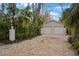 Two-car garage with gravel driveway and mature landscaping at 320 29Th Nw St, Bradenton, FL 34205