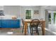 Kitchen features blue shaker cabinets, a wooden table and chairs, and access to backyard at 320 29Th Nw St, Bradenton, FL 34205
