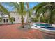 Kidney shaped pool with brick patio and tropical landscaping at 320 29Th Nw St, Bradenton, FL 34205