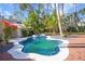 Freeform pool with brick patio and spa, surrounded by lush landscaping at 320 29Th Nw St, Bradenton, FL 34205