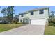 Two-story light green house with a white garage door and well-maintained lawn at 4371 Balsey St, North Port, FL 34286