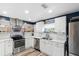 Modern white kitchen with stainless steel appliances and hexagon tile backsplash at 4371 Balsey St, North Port, FL 34286