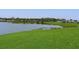 Serene lakefront view with lush green grass at 4531 13Th E St, Ellenton, FL 34222