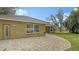 Tan house exterior with tile roof, window, and paved patio at 5401 Oak Grove Ct, Sarasota, FL 34233