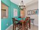Small dining area with wooden table and chairs and teal walls at 615 Riviera Dunes Way # 104, Palmetto, FL 34221
