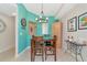 Small dining area with wooden table and chairs and teal walls at 615 Riviera Dunes Way # 104, Palmetto, FL 34221