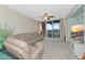Spacious living room with large TV and access to balcony at 615 Riviera Dunes Way # 104, Palmetto, FL 34221