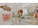 Bathroom with double vanity, granite countertop, and large mirror at 635 Key Royale Dr, Holmes Beach, FL 34217