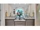 Double vanity with granite countertop and a round window in the bathroom at 635 Key Royale Dr, Holmes Beach, FL 34217