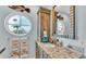 Bathroom boasts granite countertop, large mirror, and nautical decor at 635 Key Royale Dr, Holmes Beach, FL 34217