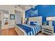 Primary bedroom with blue walls, sliding barn door, and hardwood floors at 635 Key Royale Dr, Holmes Beach, FL 34217