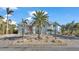 Two-story waterfront home with light blue siding, palm trees and a brick driveway at 635 Key Royale Dr, Holmes Beach, FL 34217