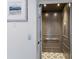 Elegant private elevator with wood paneling and geometric tile flooring at 6605 Gulf Dr, Holmes Beach, FL 34217