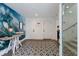 Bright entryway with ocean-themed wall art, geometric tile flooring, and white doors at 6605 Gulf Dr, Holmes Beach, FL 34217