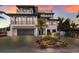 Modern three-story home with a large driveway and palm trees at 6605 Gulf Dr, Holmes Beach, FL 34217