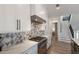 Modern kitchen with white cabinets, geometric backsplash, and gas cooktop at 6605 Gulf Dr, Holmes Beach, FL 34217