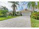 Single-story home with attached garage and landscaped yard, featuring a large driveway at 6710 Pebble Beach Way, Lakewood Ranch, FL 34202