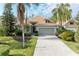 Single-story house with tile roof, gray garage door, and landscaped yard at 6710 Pebble Beach Way, Lakewood Ranch, FL 34202