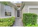 Front entry with black iron door and sidelights, and lush landscaping at 6710 Pebble Beach Way, Lakewood Ranch, FL 34202