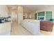 White kitchen with island, gas range and access to living room at 6710 Pebble Beach Way, Lakewood Ranch, FL 34202