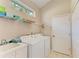 Bright laundry room, washer, dryer, and ample shelving at 6710 Pebble Beach Way, Lakewood Ranch, FL 34202